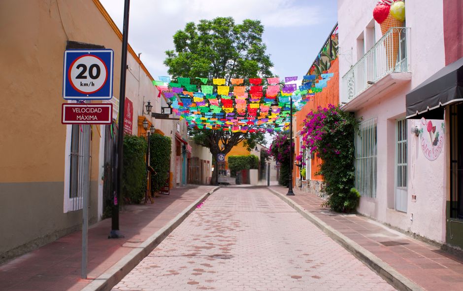 A quiet, charming cobblestone street in the historic art district of San José del Cabo, lined with colorful colonial buildings and boutique shops.
