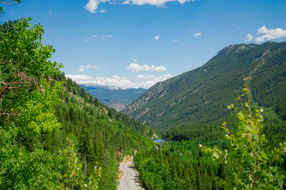 A scenic, winding road cuts through a vast Colorado mountain valley on a clear day, representing the forward-looking journey of navigating financial changes.